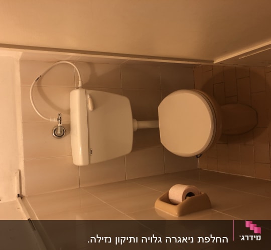 אסלה עם מיכל הדחה וצינור מים